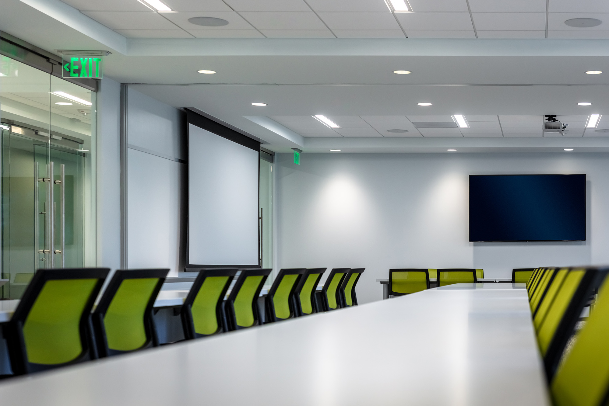 Large, modern conference room with a large TV and projector
