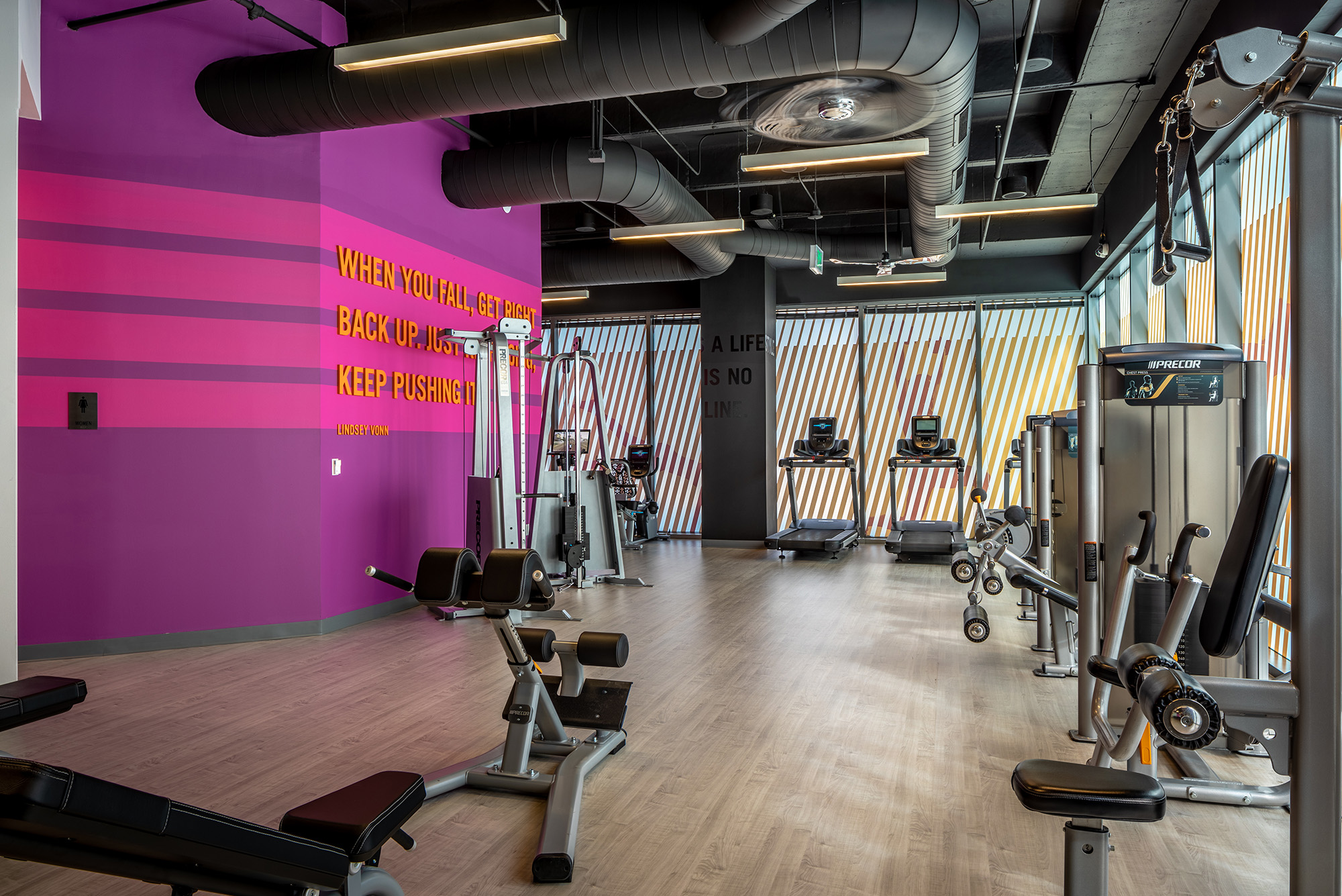 Bright, modern fitness center with weight lifting equipment and treadmills
